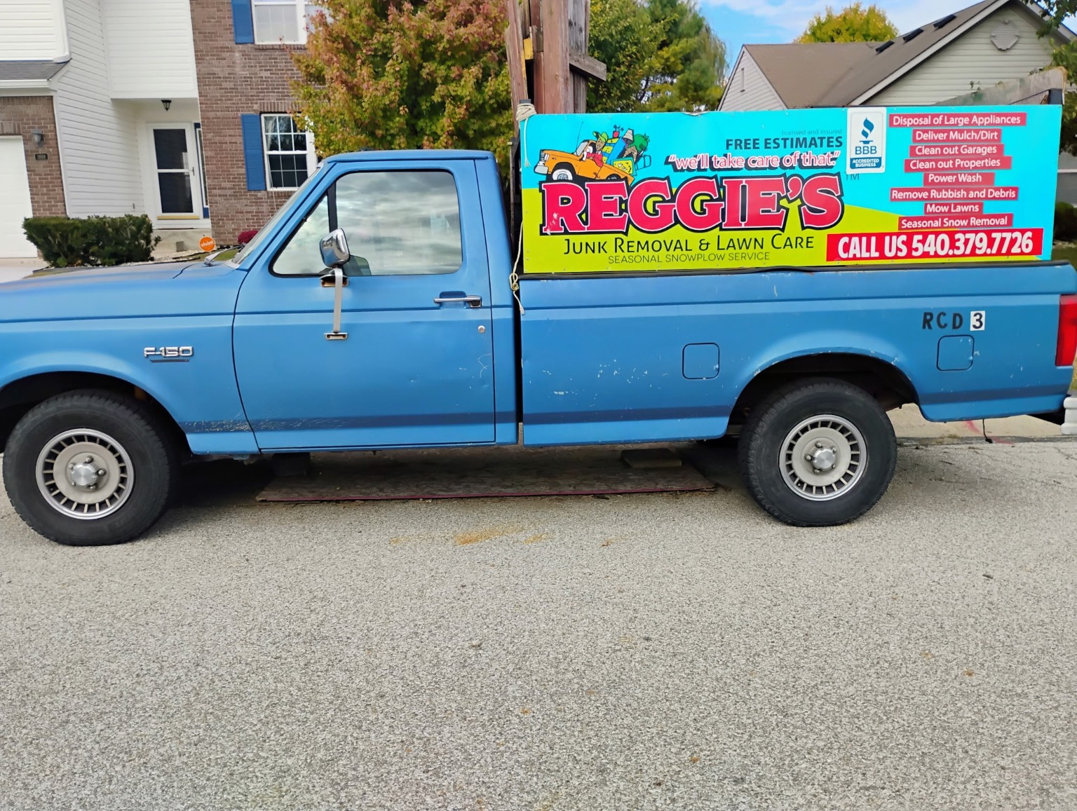 Reggie's complete blue work truck with colorful business signage